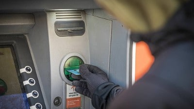 persoon neemt geld op bij pinautomaat