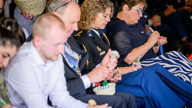 Op de kiezelstenen wordt een persoonlijke boodschap voor een overledene geschreven.